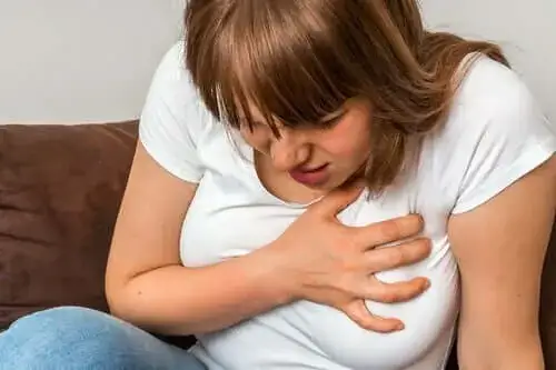 Kobieta z objawami lęku, trzymająca się za głowę lub klatkę piersiową